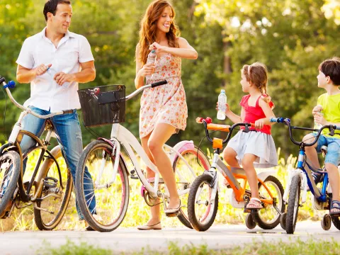 A family takes time to hydrate during a summer bike ride.