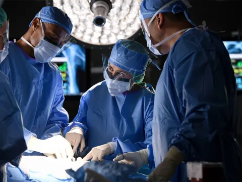 Surgeons in an operating room performing surgery.