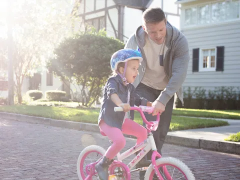 Dad taking his daughter on a bike ride.