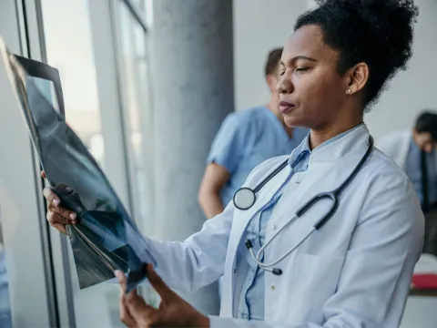 A female doctor looking at a body scan image.