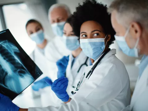 Masked physicians reviewing thoracic chest x-ray