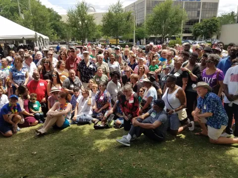 A large group of people gathered for a picnic photo