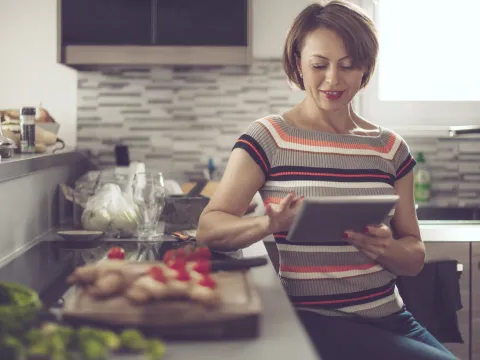 woman in kitchen reading tablet