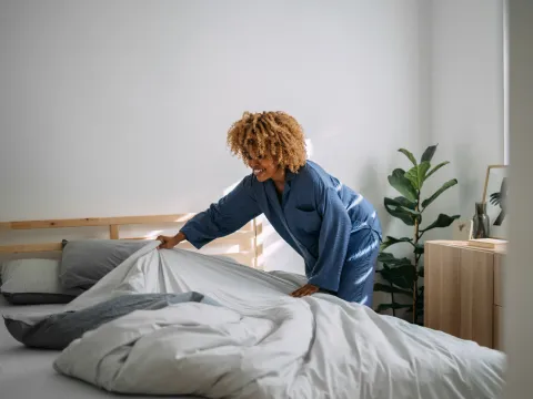 Woman making her bed in the morning.