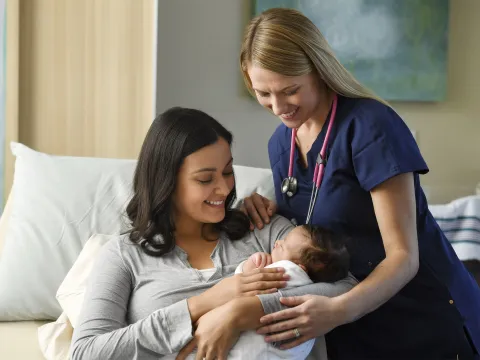 Mother and female physician holding baby