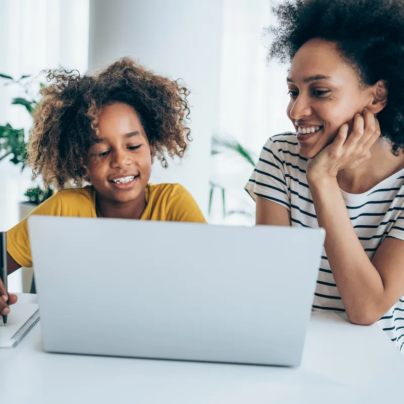 A Mother and Daughter Surf the Internet on a Laptop in Their Home.
