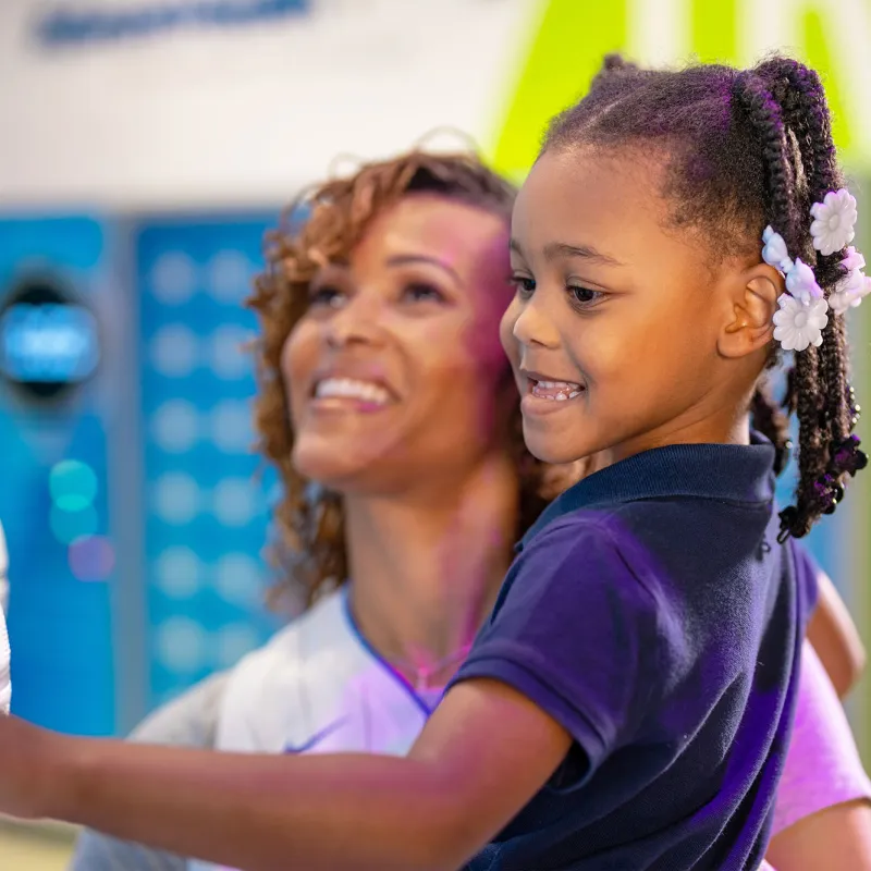 A Woman Hold Her Daughter in the Gift Shop of The Amway Center