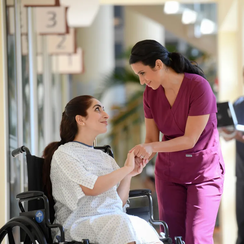 Female nurse giving a hopeful smile to female patient.