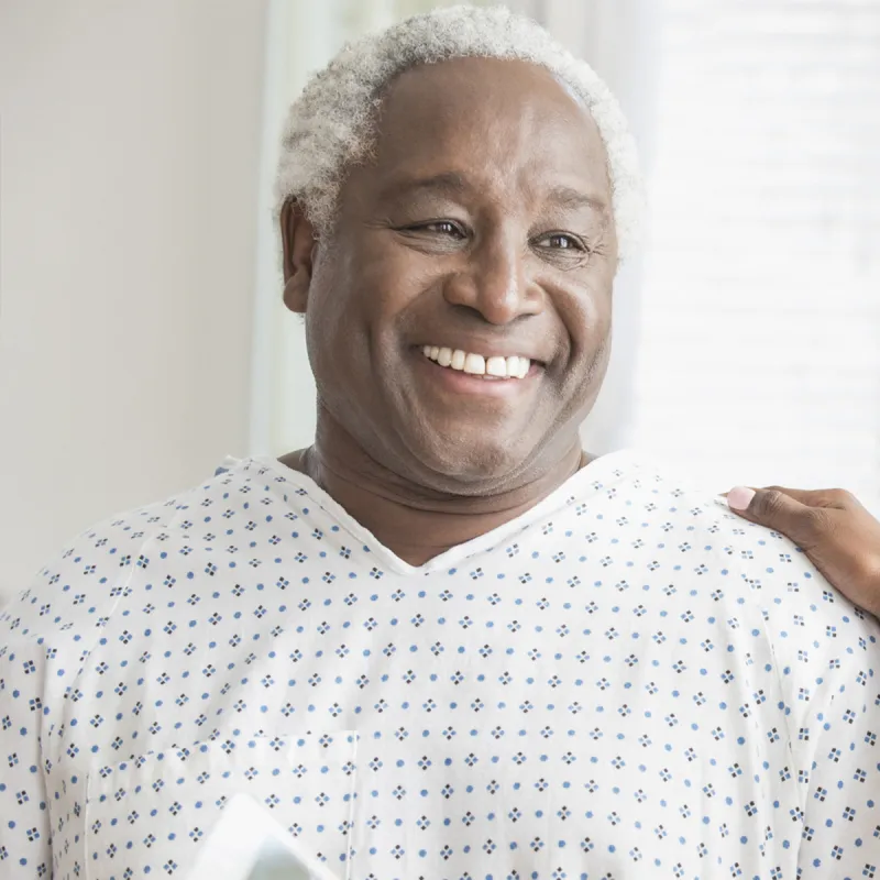 An older African American man receives consolation from a female physician.