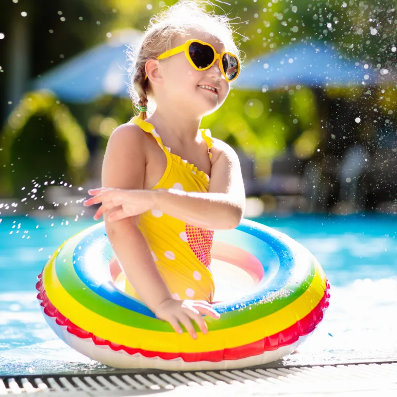 A little girl enjoys a refreshing dip in the pool.