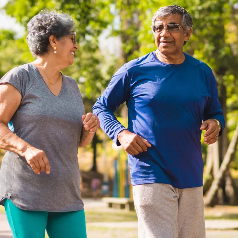 A mature couple exercising outdoors together.