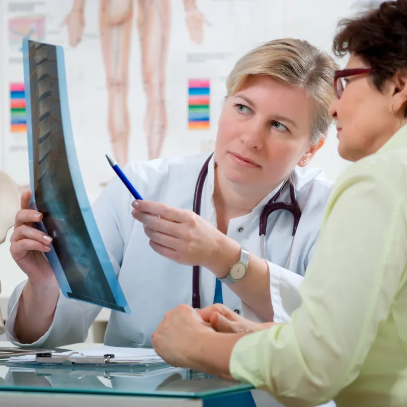 A woman looks at her back x-ray with her doctor