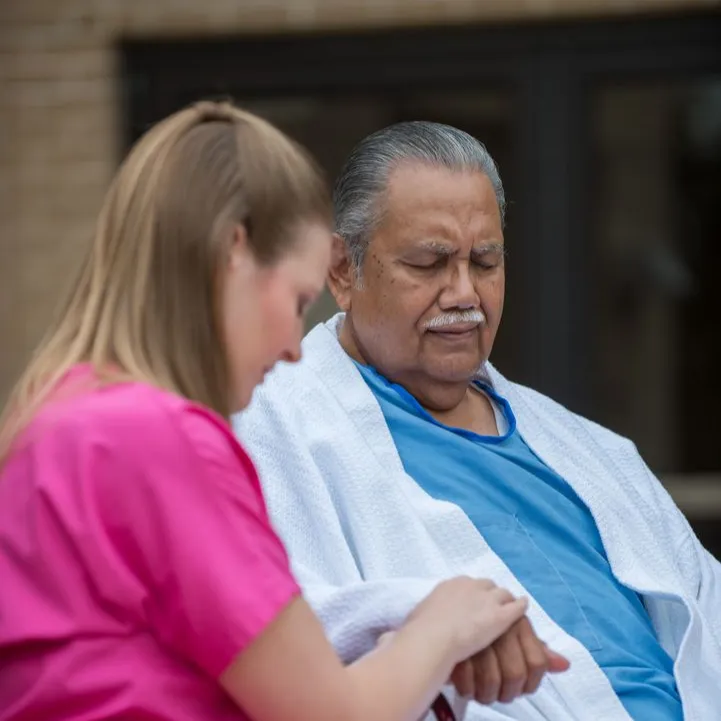 Nurse praying with patient.