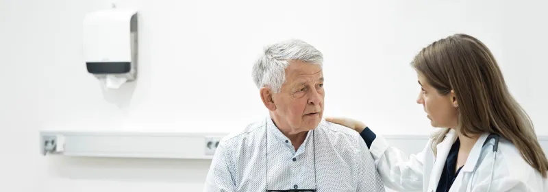 Older man talking with his doctor in an exam room