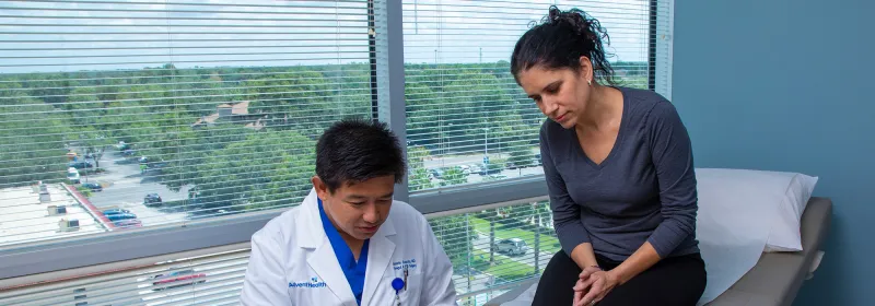 Dr. Iswanto Sucandy showing patient a something on a laptop.