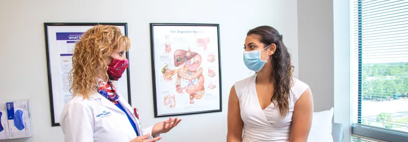 Doctor Sharona Ross talking with patient while wearing masks.