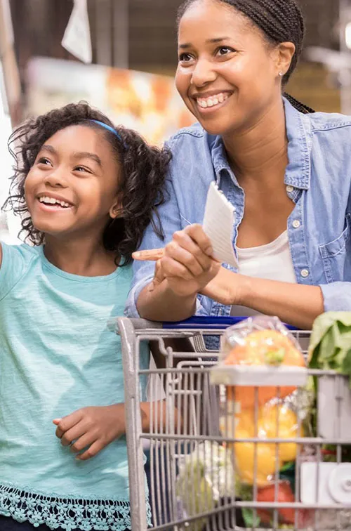 A mother and daughter shop for nutrient-rich vegetables at the supermarket. 