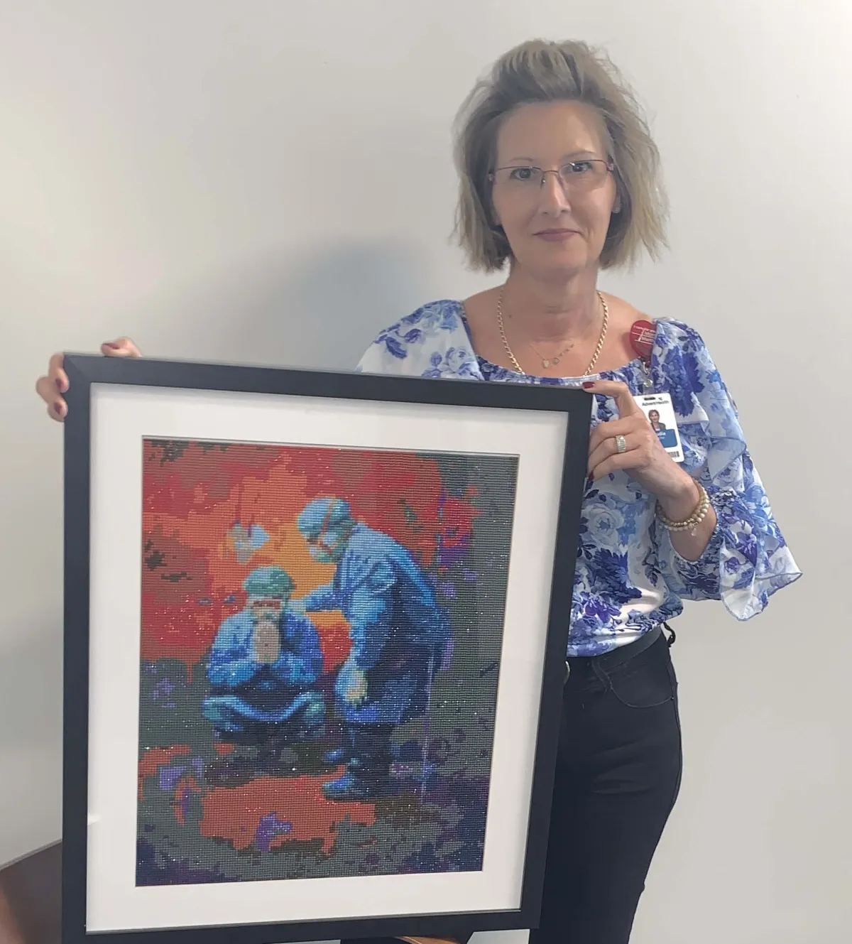Claudia Colache Klein holding one of her art pieces