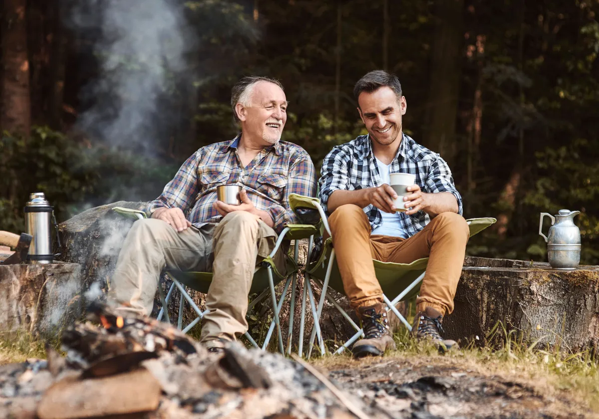 A father and son sitting in front of a campfire