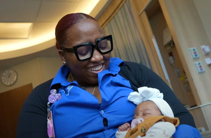 Fourth Trimester care coordinator Erike King holds a baby.