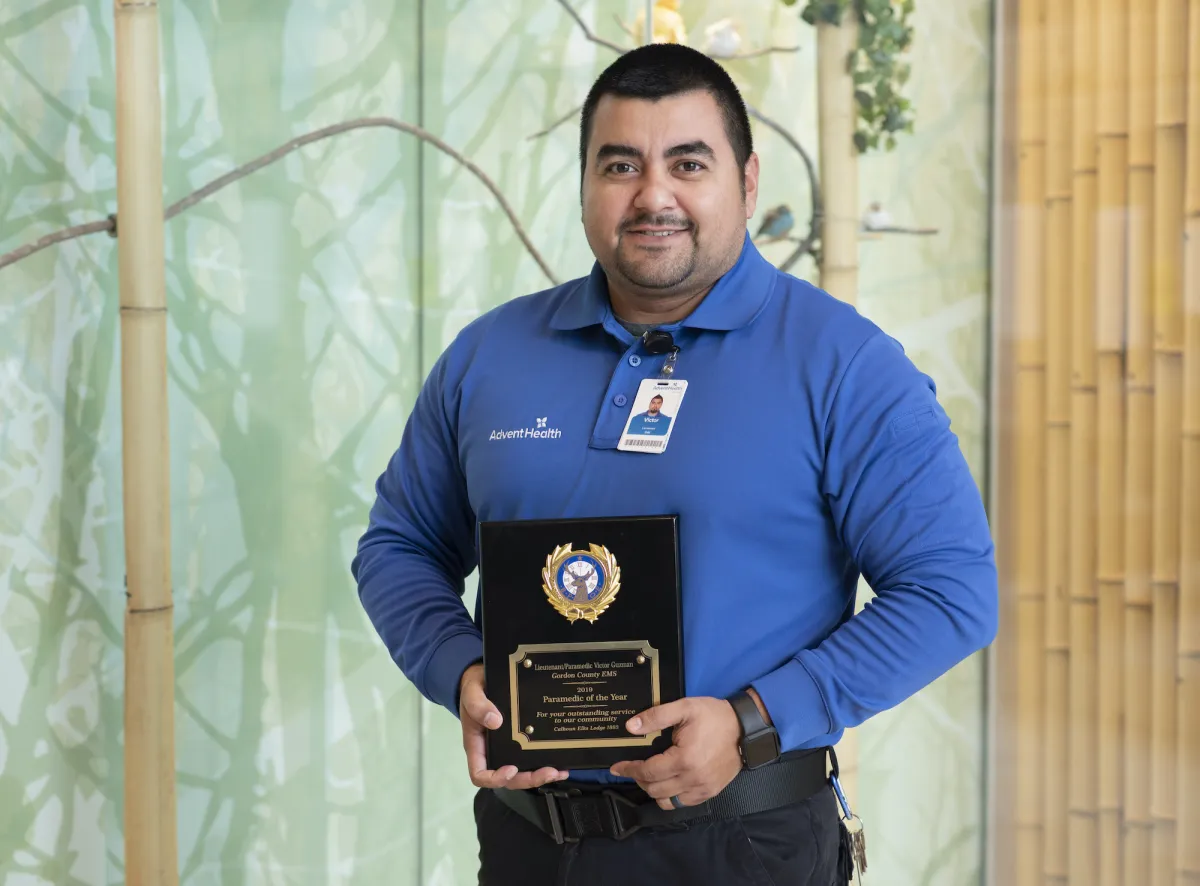 Victor Guzman holding an award.